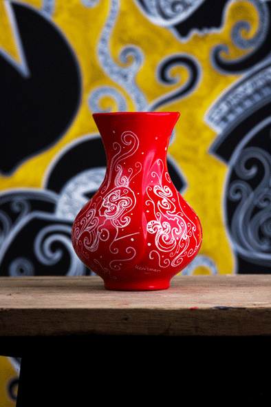 Red vase perfect to put flowers in, contains a beautiful elegant hand drawn artwork with with acrylic paint by artist kennetn kenisman. The artwork on the object depicts a nature scene, with curls, waves, sea or nature elements and intricate details. Also silhouette figures wearing an ancient helmet. The composition is well balanced.